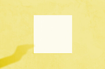 Summer modern sunlight stationery mockup scene. Flat lay top view blank greeting card with hand shadow overlay on grunge background. Illuminating Pantone Color Of The Year 2021.