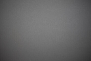 Black cardboard background with closeup on a piece of black colored paper.