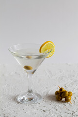 margarita cocktail in the bar. martini glass of cocktail with olives on white background. Glasses for martini with lemon on the table. copy space. alcohol drinks. vertical