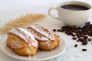 Traditional french eclairs on table. coffee cup with coffee beans and  on white background. tasty dessert. copy space