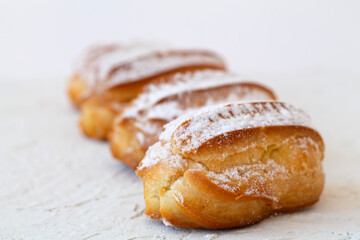 Close-up vanilla eclairs on a background. copy space. Traditional french tasty dessert.