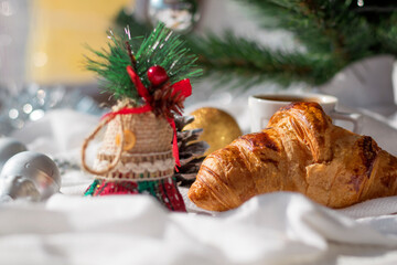 Croissant fresh backed, cup of coffee and christmas and new year decorations on white background