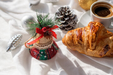 Obraz na płótnie Canvas Croissant fresh backed, cup of coffee and christmas and new year decorations on white background