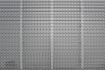 Texture of a perforated corrugated aluminum sheet facade.