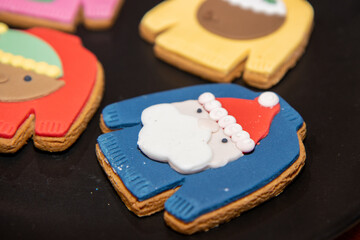 Festive Christmas cookies in the shape of a Christmas jumper on a wooden work top