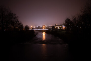 Stadt mit Fluss im Vordergrund in der Nacht