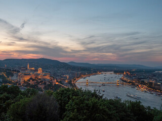 view of the of buda castle, chain bridge and danube river at dusk from citadella in budapest