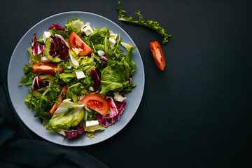 Mix salad with tomatoes, feta, lettuce, spinach. Top view with text space