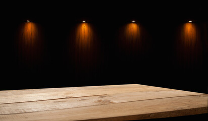 empty wooden table on which beams of light from lamps fall on a dark background, place for your products on the table