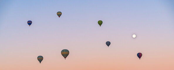 Hot air balloon flying over Cappadocia, pink sky