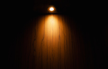 empty wooden table on which beams of light from lamps fall on a dark background, place for your products on the table