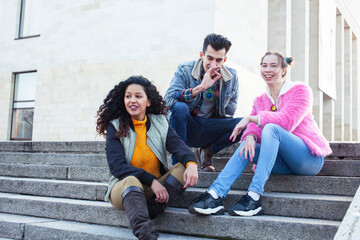 Obraz premium cute group of teenages at the building of university with books huggings, diversity nations real students lifestyle