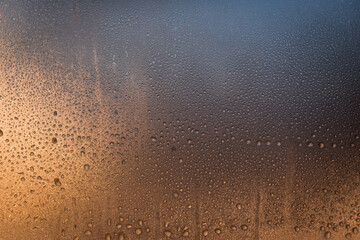 Water drops frozen to a window at sunrise