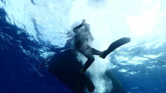 boat underwater scuba diver jumps into water to start diving ocean scenery