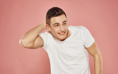 A man in a white t-shirt on a pink background emotions elegant style Studio