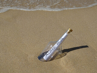 Message in a bottle washed up on a sandy beach.