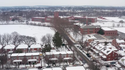 Aerial of urban city housing in USA with school buildings in distance. Virtual learning from home during COVID-19 pandemic. Education in inner city America.