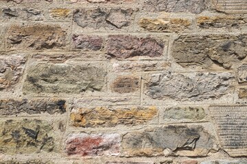Colorful rough stone wall with irregular blocks set in contrasting mortar abstract architecture background