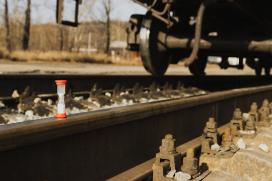 Railway freight cars on rails with hourglass, the concept of saving time on railway transportation.