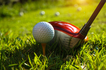 Golf club and ball on tee in grass. Golf balls on the golf course with golf clubs ready for the first short. In the morning, with the beautiful light. Sports that people around the world.