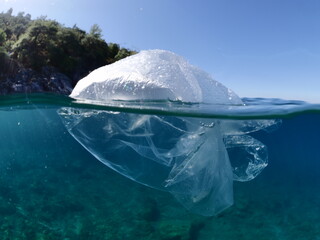 split shot of plastic bag underwater ocean polltion global waste like iceberg
