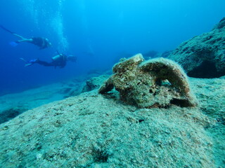 Naklejka na ściany i meble scuba diver underwater exploring ancient amphoras deep water history search