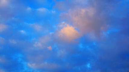 View of the blue sky with white and gray fluffy clouds on a sunny day