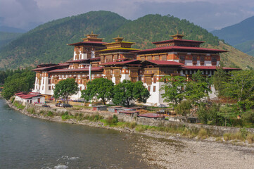 Fototapeta premium Scenic landscape view of ancient historic landmark Punakha dzong on bank of Mo Chhu river, Western Bhutan 