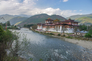 Fototapeta na wymiar Panoramic view of impressive Punakha dzong in Western Bhutan with Mo Chhu river and cantilever bridge