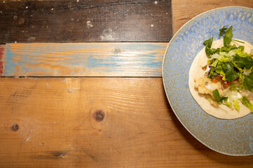 A delicious plate of Cornish Cod Tacos with a slice of Lime on a wooden kitchen work top