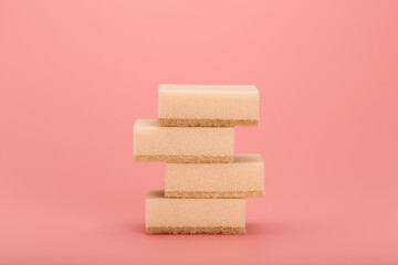 Stack of sponges for dish washing or home cleaning on bright pink background