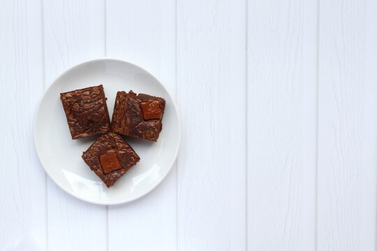 Homemade brownies with milk chocolate chunks on top. Half composition, negative space on the right