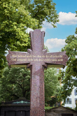 großes Steinkreuz mit einem Bibelspruch