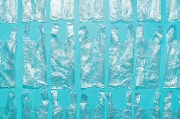 Plastic bags aligned on a blue background. Several single-use bags above view.
