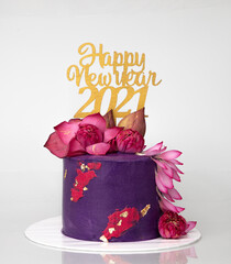 New Year Greeting Cake in Blue purple red and gold colours with Fresh Blue water Lilies