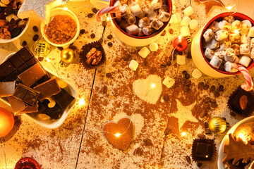 sweet food top view background for merry christmas or new year holiday decoration with night illumination - chocolate candies, tangerines, cookies, marshmallow and cocoa latte on white wood