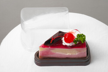 a piece of strawberry jelly cheesecake in the take away plastic box - 402524454