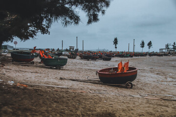 Thung cai or traditional Vietnamese basket boats moored at the beach on a dark and moody day