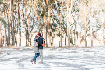 Fototapeta na wymiar Young hipster couple hugging each other in winter park. Winter love story, a beautiful stylish young couple.