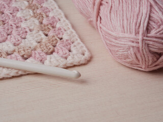 Needlework crochet, top view of yarn balls, flat spoon on light wood close-up