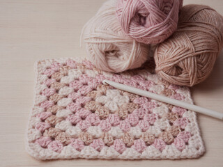 Needlework crochet, top view of yarn balls, flat spoon on light wood close-up