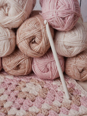Needlework crochet, top view of yarn balls, flat spoon on light wood close-up