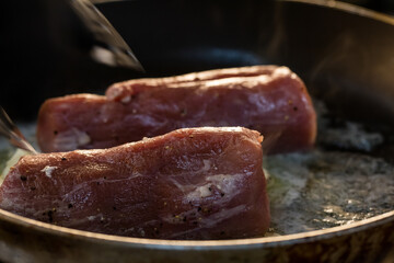 Cooking fresh meat in a dark kitchen 
