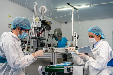 Staff and workers at the mask factory are monitoring the operation of the machines. A mask is being produced on the road.