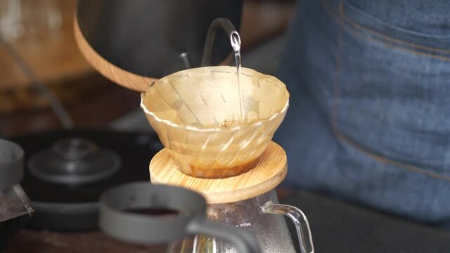 Hand drip worm water into coffee, Barista making drip coffee.