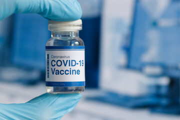 covid-19 vaccine in a medical research lab, a bottle of covid-19 vaccine, syringe for injection of vaccination, hand holding vaccine, covid-19 cure testing