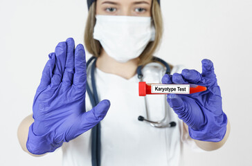 The doctor holds in his hands a test tube with blood tests for the Karyotype, with the other hand...