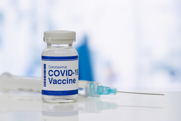 covid-19 vaccine in a medical research lab, a bottle of covid-19 vaccine, syringe for injection of vaccination, hand holding vaccine, covid-19 cure testing