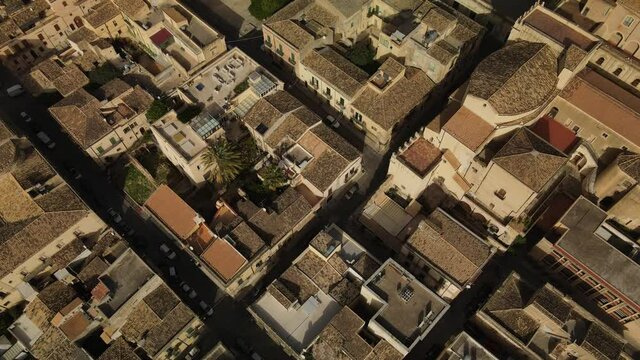Aerial view of the ancient sicilian famous town Noto, UNESCO world heritage site in Sicily. Drone flies above the typical sicilian roofs and narrow streets
