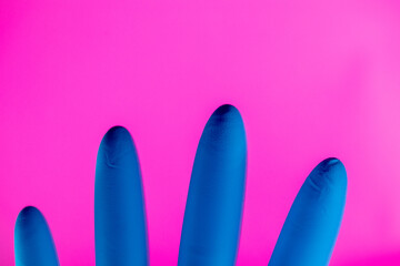 Latex surgical or medical glove . New Corona virus infection (novel corona virus disease) background. Pandemic panic concept. Pink Background
